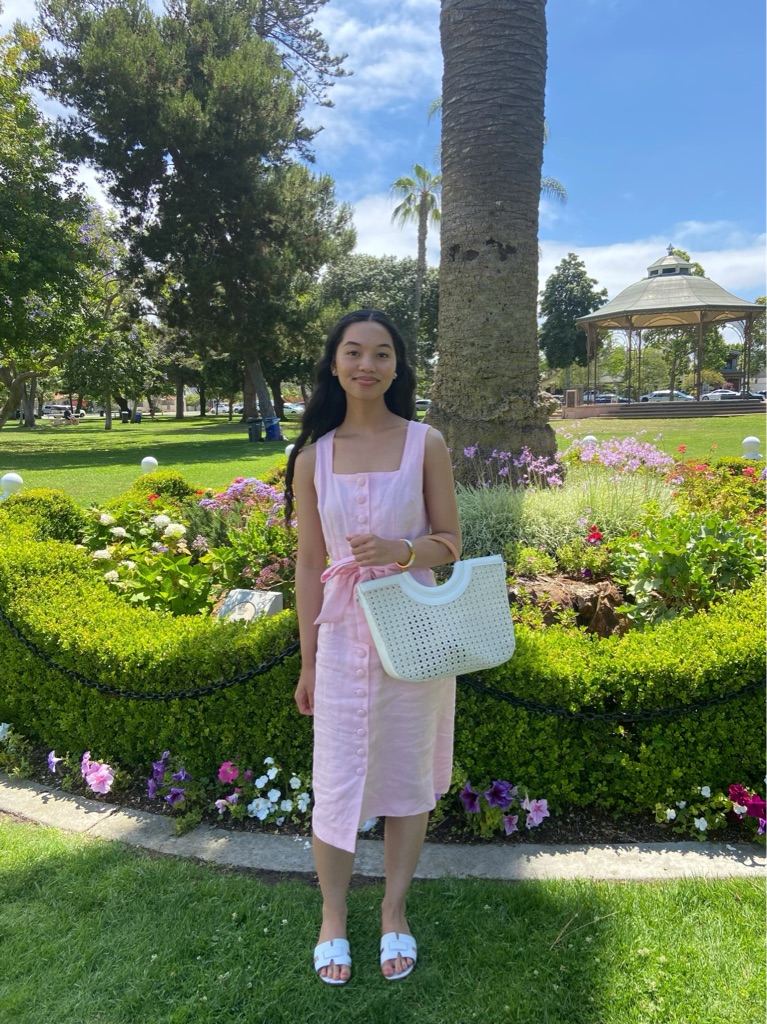 girl wearing pink linen dress while standing in a garden